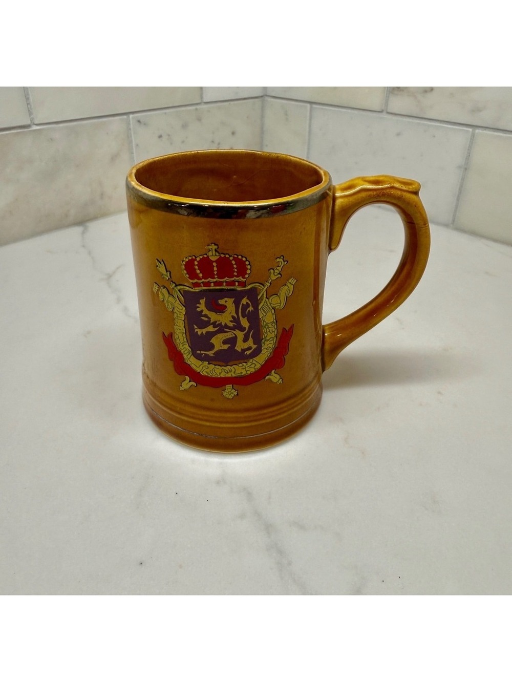 Brown ceramic mug with crest design